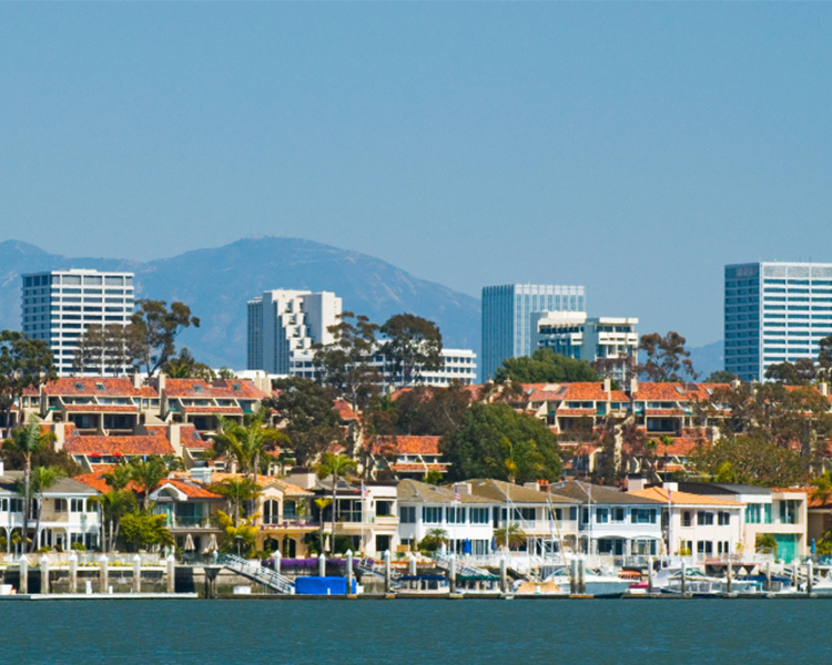 Split image showing a coastal city skyline with mountains in the background on the left and an empty courtroom with a judge's chair and American flag on the right.